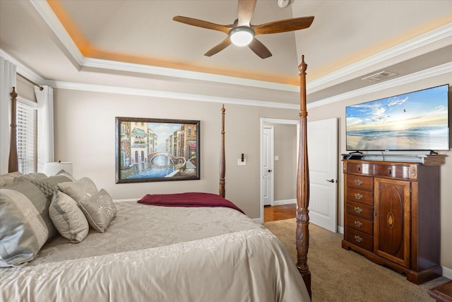 carpeted bedroom featuring a raised ceiling, visible vents, and crown molding