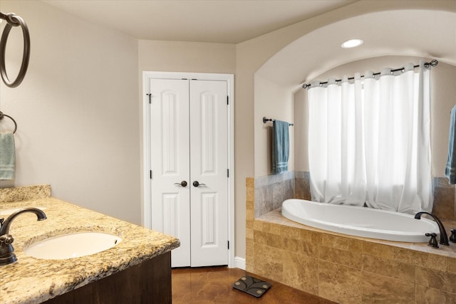 full bath with tile patterned floors, tiled tub, a closet, and vanity