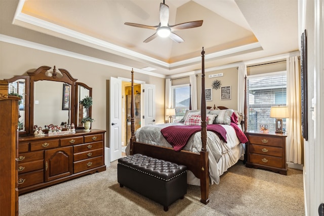 bedroom featuring ceiling fan, light colored carpet, ornamental molding, and a tray ceiling