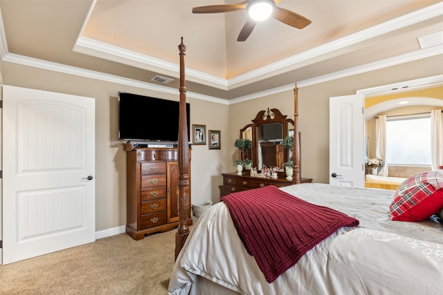 bedroom with light carpet, a tray ceiling, ceiling fan, and crown molding