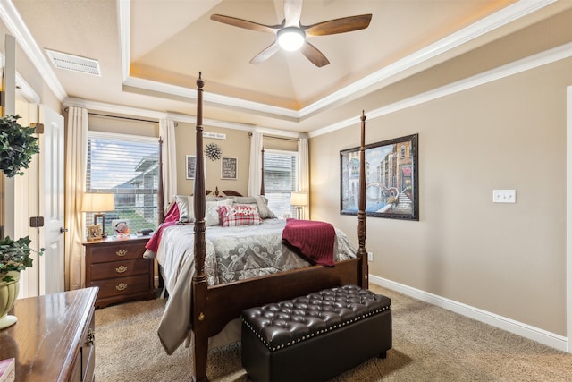 bedroom with ceiling fan, a raised ceiling, ornamental molding, and light carpet