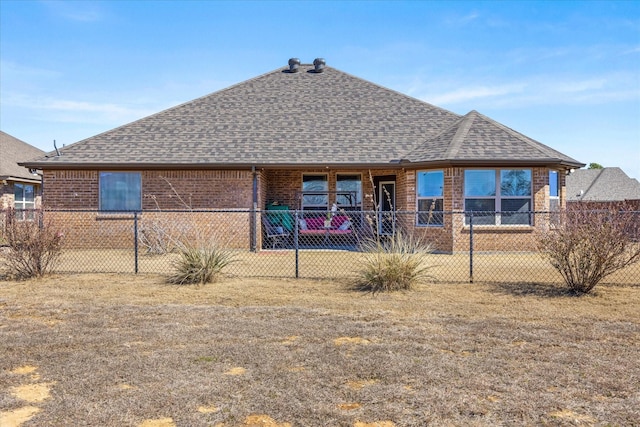 back of property with brick siding, fence, and roof with shingles