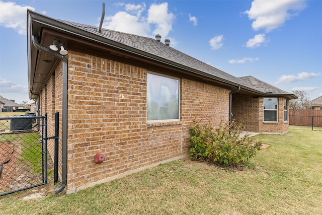 view of side of property featuring central AC unit and a yard