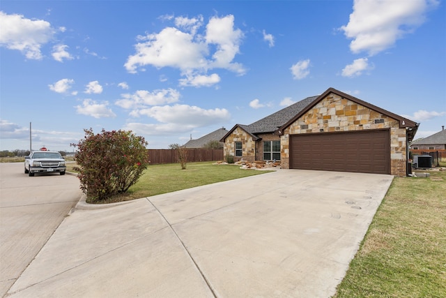 view of front facade featuring a garage, a front lawn, and cooling unit