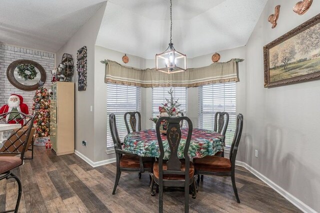 dining space with dark hardwood / wood-style floors, vaulted ceiling, and a notable chandelier