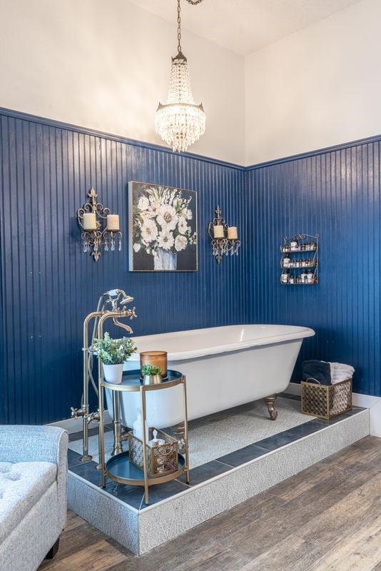 bathroom with a towering ceiling, hardwood / wood-style floors, and a notable chandelier