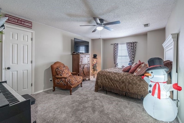 bedroom with ceiling fan, carpet floors, and a textured ceiling