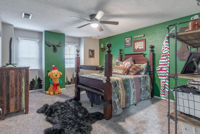 carpeted bedroom with ceiling fan and a textured ceiling