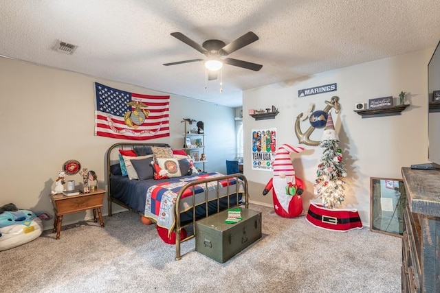 carpeted bedroom with ceiling fan and a textured ceiling