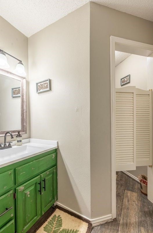 bathroom with vanity, hardwood / wood-style floors, and a textured ceiling