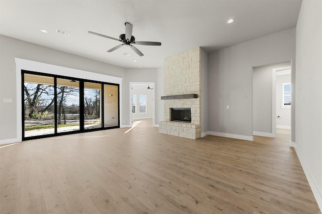 unfurnished living room featuring a fireplace, light hardwood / wood-style floors, and ceiling fan