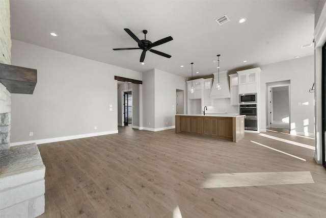 unfurnished living room featuring light hardwood / wood-style floors and ceiling fan