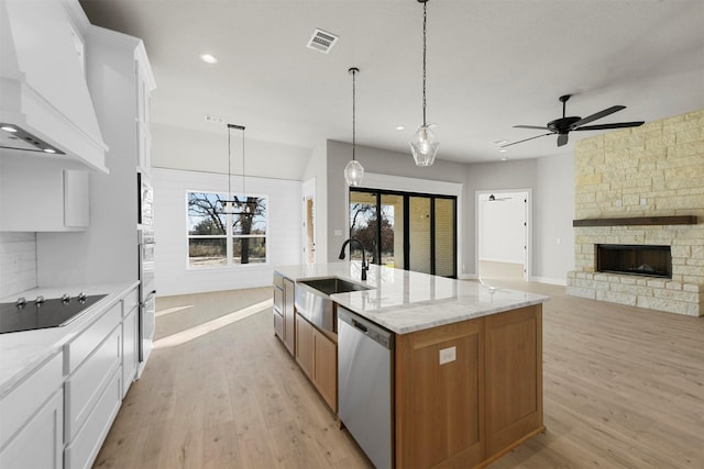 kitchen with white cabinets, black electric stovetop, premium range hood, and dishwasher