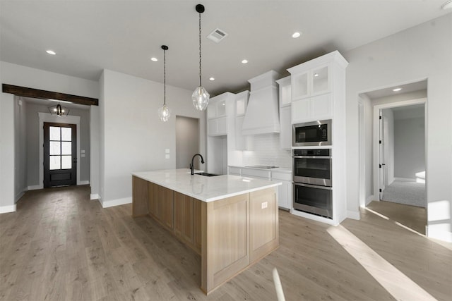 kitchen featuring built in microwave, white cabinetry, backsplash, a spacious island, and custom exhaust hood