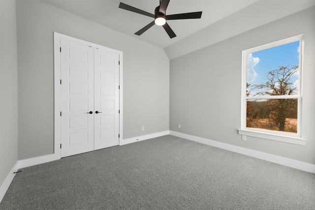 unfurnished bedroom featuring carpet, ceiling fan, a closet, and vaulted ceiling