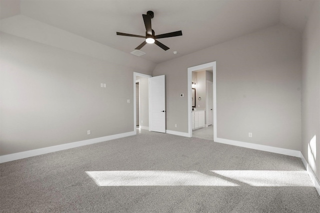 unfurnished bedroom featuring ensuite bathroom, ceiling fan, light carpet, and vaulted ceiling