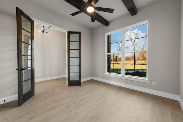 unfurnished room with beamed ceiling, french doors, light hardwood / wood-style flooring, and a healthy amount of sunlight