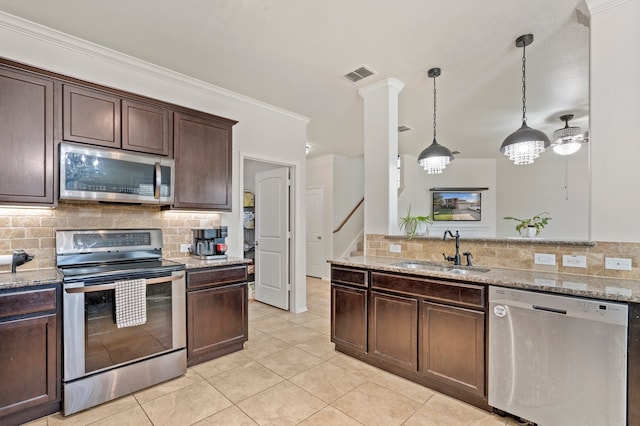 kitchen featuring decorative backsplash, appliances with stainless steel finishes, dark brown cabinets, sink, and pendant lighting