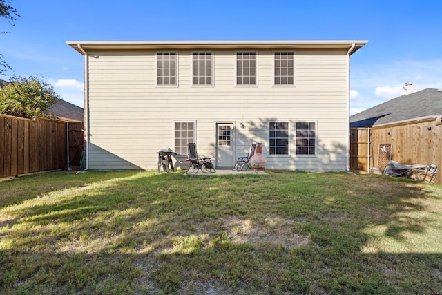 back of house featuring a patio area and a lawn