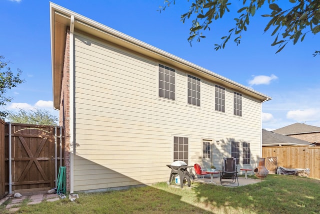 back of house with a patio area and a yard