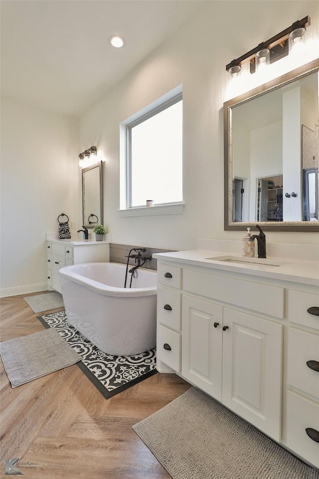 bathroom with vanity, parquet floors, and a washtub