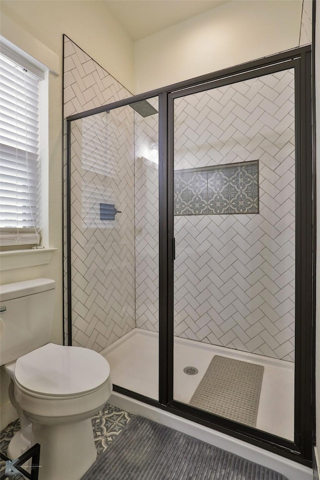 bathroom with an enclosed shower and toilet