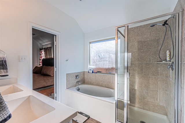 bathroom featuring vanity, wood-type flooring, vaulted ceiling, and shower with separate bathtub