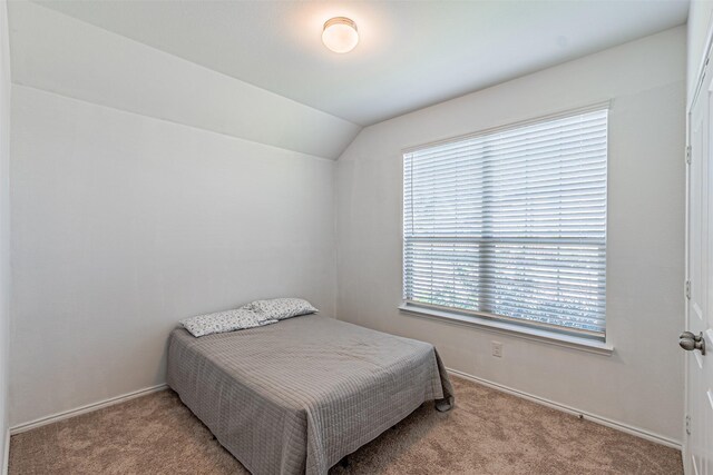 bedroom with light carpet, multiple windows, and lofted ceiling