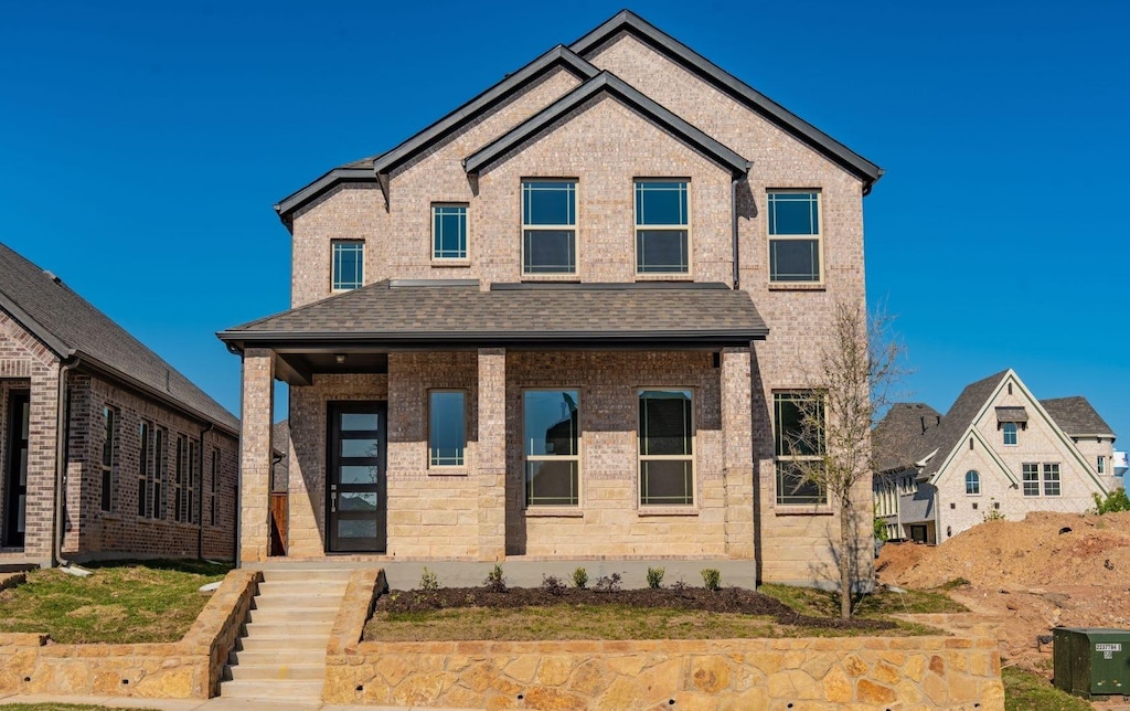 traditional-style house featuring brick siding and a shingled roof