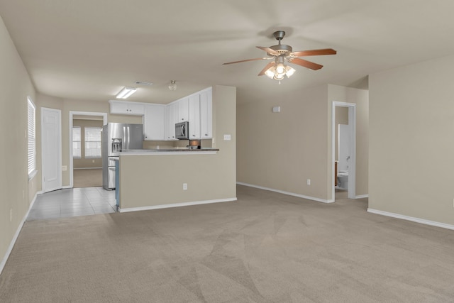 unfurnished living room featuring ceiling fan and light colored carpet