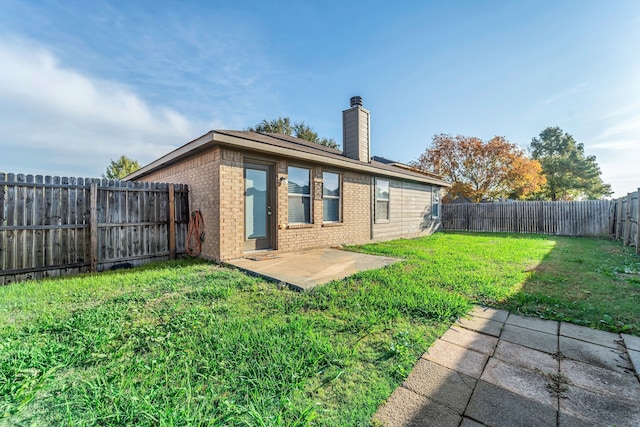 rear view of property with a yard and a patio