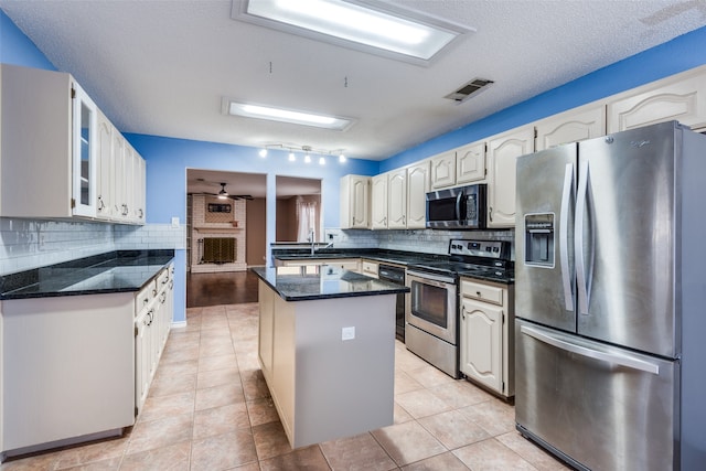 kitchen featuring a textured ceiling, stainless steel appliances, and backsplash