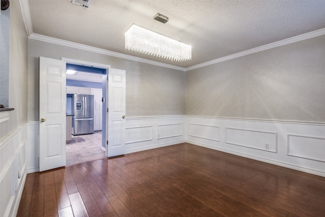 spare room with wood-type flooring, a textured ceiling, and ornamental molding