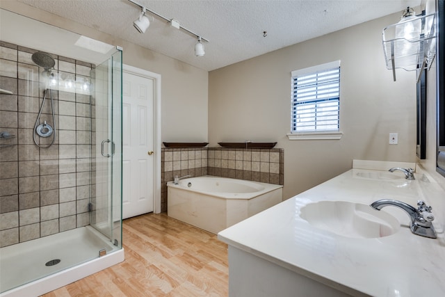 bathroom featuring vanity, wood-type flooring, a textured ceiling, and shower with separate bathtub