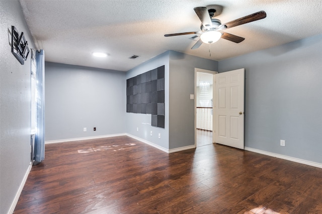 unfurnished room with ceiling fan, dark hardwood / wood-style flooring, and a textured ceiling