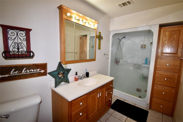 bathroom with vanity, toilet, tile patterned flooring, and a shower