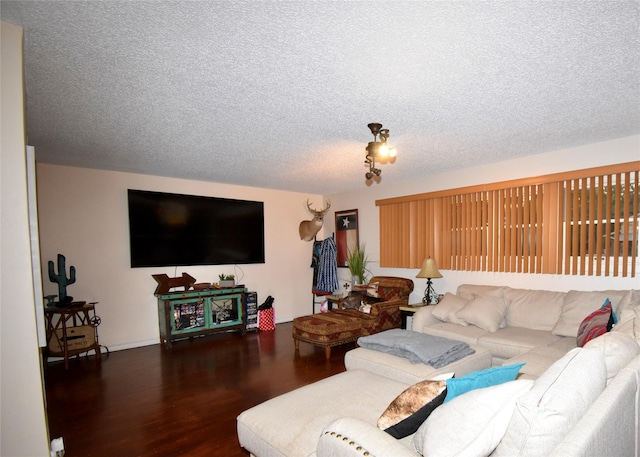 living room featuring dark wood-type flooring and a textured ceiling