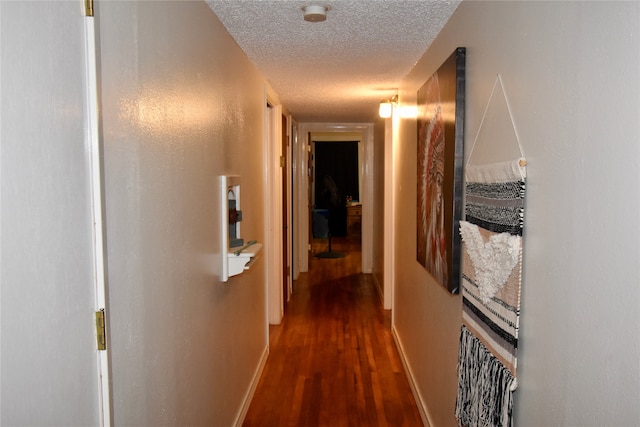 hall featuring dark hardwood / wood-style flooring and a textured ceiling