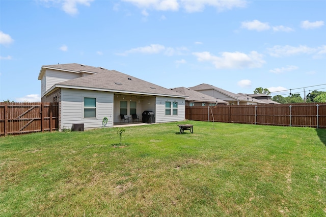 back of property featuring a fire pit, a patio area, and a lawn