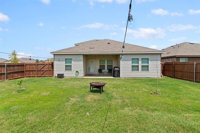 rear view of house featuring a yard and a fire pit