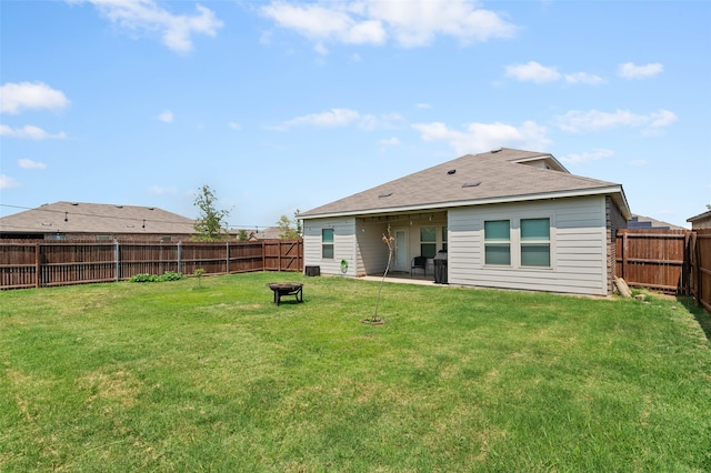 back of house featuring an outdoor fire pit, a patio area, and a lawn