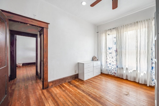 unfurnished room with ceiling fan, baseboards, and wood finished floors