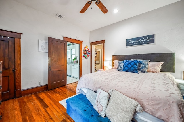 bedroom with visible vents, ensuite bathroom, dark wood-type flooring, ceiling fan, and baseboards