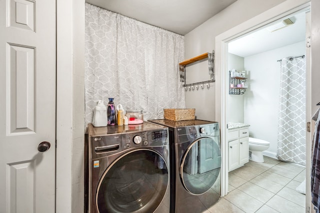 laundry area featuring light tile patterned floors, laundry area, visible vents, and washer and dryer