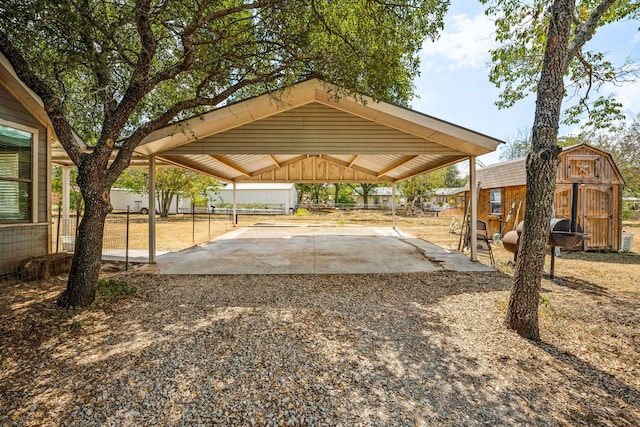 view of community featuring an outbuilding, driveway, a storage shed, and a detached carport