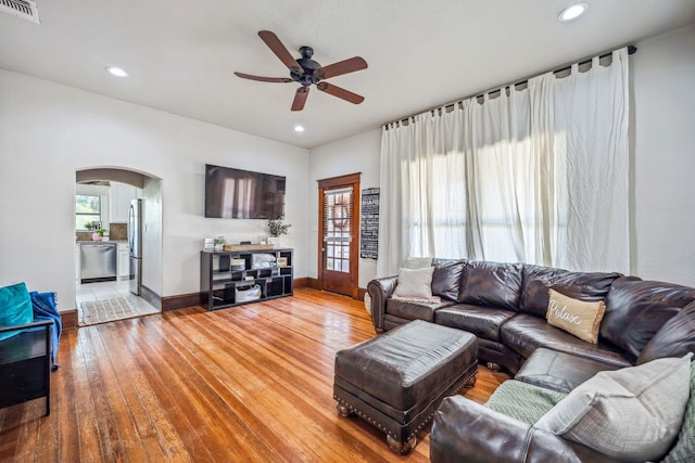 living room with arched walkways, visible vents, recessed lighting, and wood finished floors