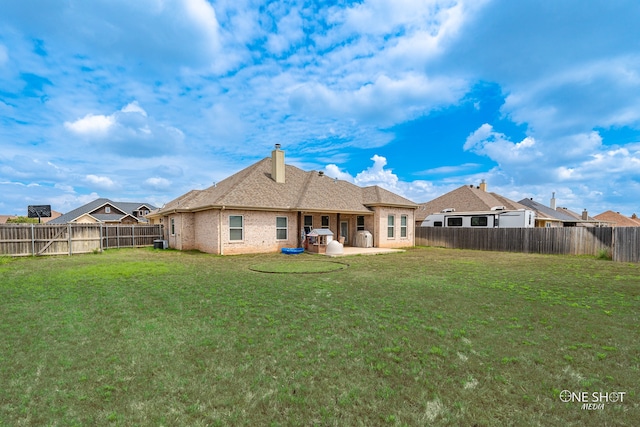 back of house with a patio area and a lawn