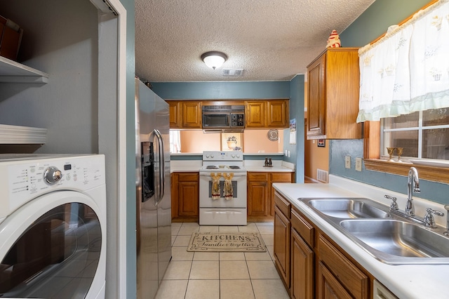 kitchen with stainless steel fridge, a textured ceiling, white range with electric stovetop, sink, and washer / clothes dryer