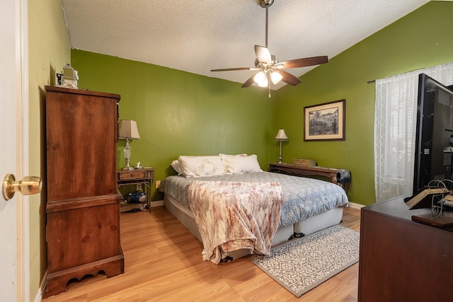 bedroom with ceiling fan, a textured ceiling, and light wood-type flooring