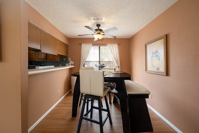 dining space featuring a textured ceiling, ceiling fan, and dark hardwood / wood-style floors